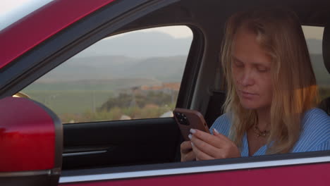 mujer conductor de coche usando teléfono inteligente