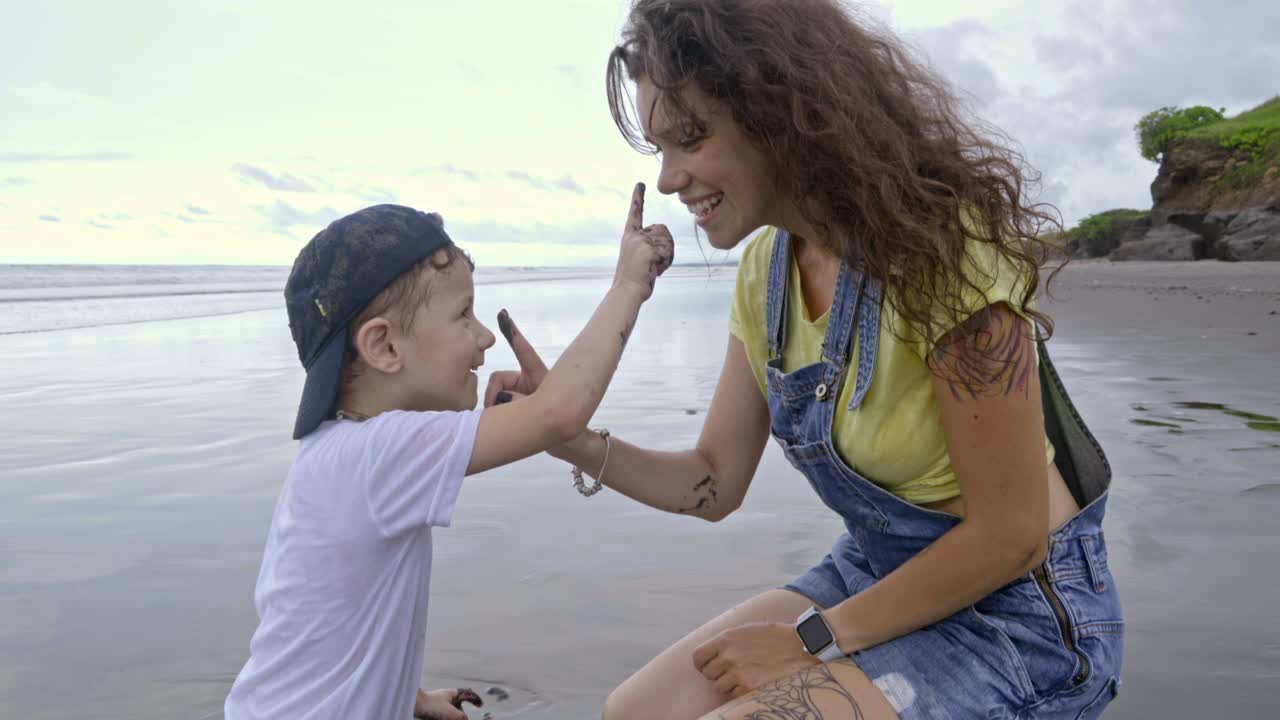 madre e hijo jugando con arena húmeda