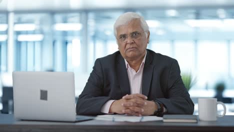 serious senior indian businessman looking at the camera