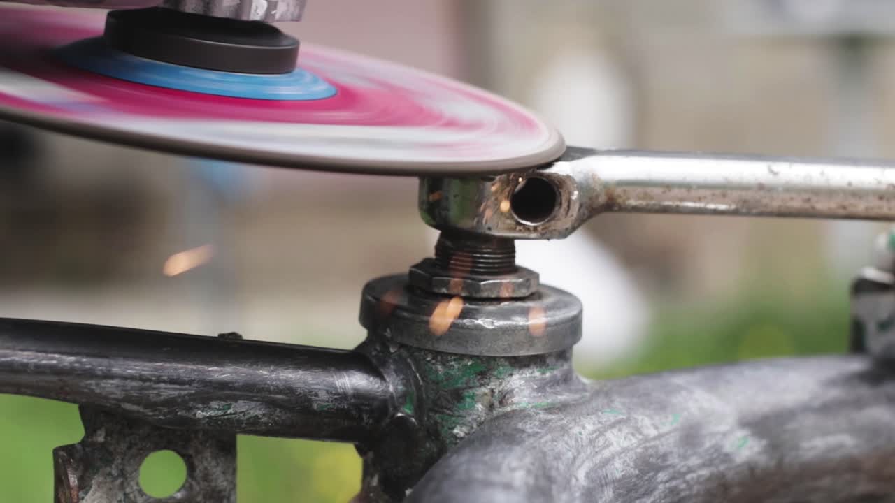 Metal worker grinding metal with a power machine