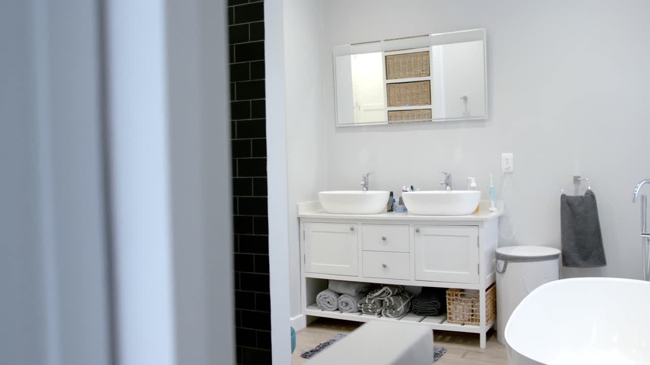 General view of bathroom with bathtub at home, mirror and washbasin, slow motion