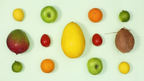 exotic summer fresh ripe fruits layout move on light green background. stop motion