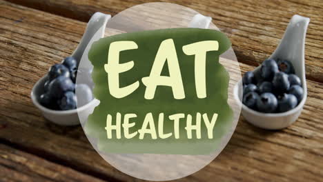 Animation-of-eat-healthy-text-over-blueberries-on-table