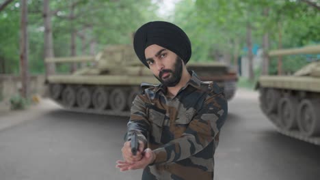 hombre del ejército indio sikh comprobando y apuntando el arma hacia el enemigo