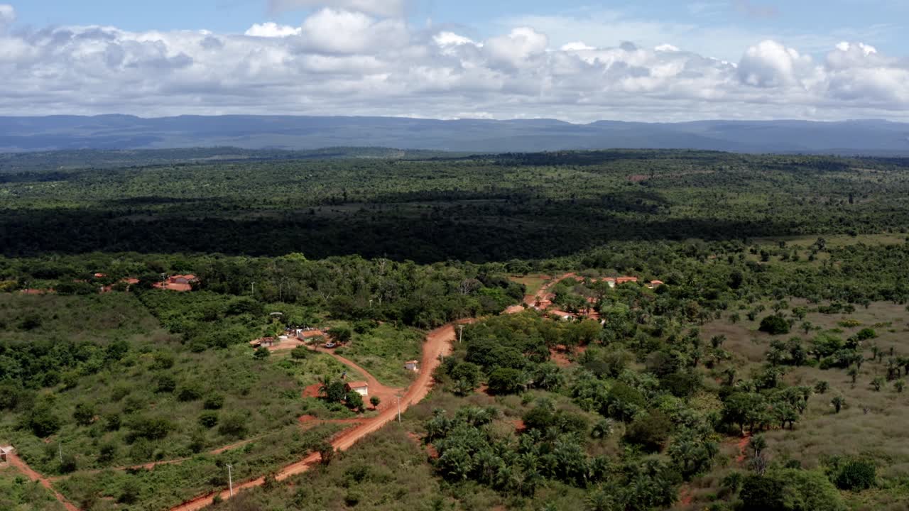 hermosa toma aérea descendente de drones del campo brasileño con un pequeño camino de tierra roja en el parque nacional chapada diamantina en el norte de brasil y un soleado día de verano lleno de nubes