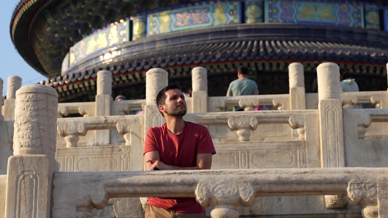 Man gazes thoughtfully at the Temple of Heaven during sunset in Beijing, China