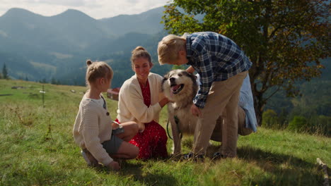 Familia-Disfrutando-De-Paseo-Mascota-En-Las-Montañas.-Gente-Pasando-Vacaciones-De-Verano-Con-Perro.