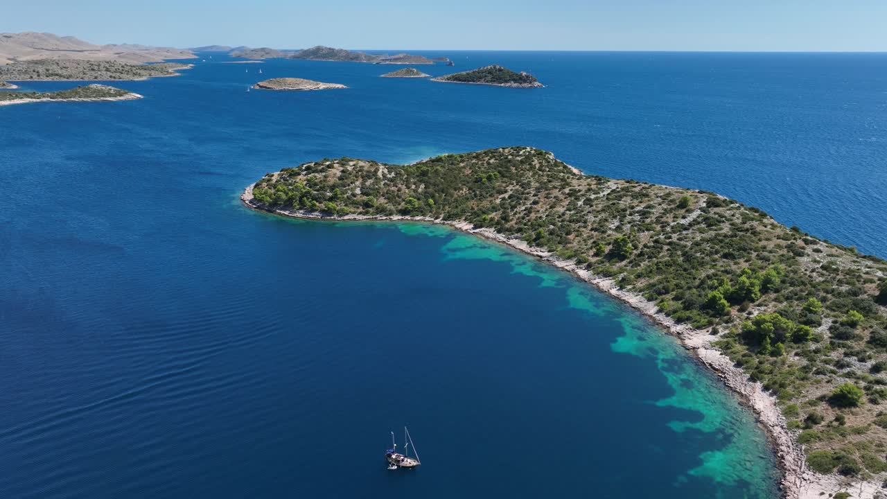 Aerial view of sailboats near lush islands in clear blue sea