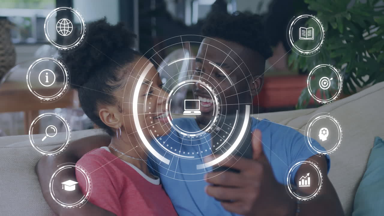 On couch, couple watching animation with digital interface icons overlaying screen