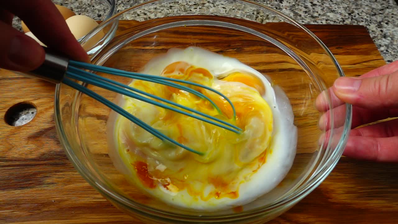 卵と牛乳で作るオムレツの準備。スローモーション。
