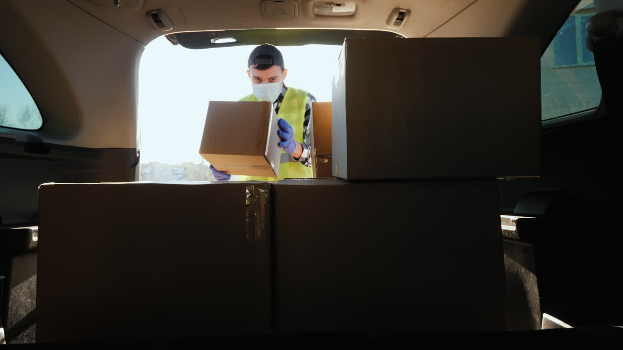 hombre carga cajas de medicamentos en el maletero del coche