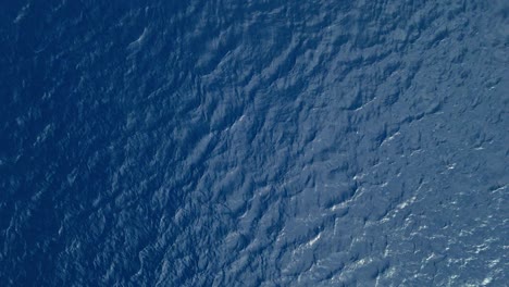 drone rises from ocean surface, a mysterious shade of deep blue