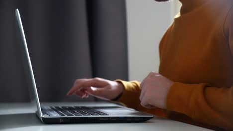 Man-shutting-down-a-laptop-computer-and-walks-away