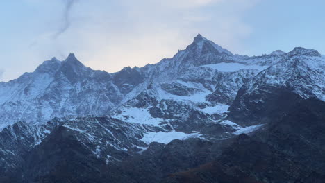 Swiss-alps-autumn-first-snow-dusting-mountain-peaks-Saas-Fee-Zermatt-Saastal-alpine-valley-chalet-ski-resort-town-sunset-orange-pink-high-clouds-Switzerland-Europe-cinematic-pan-left-motion