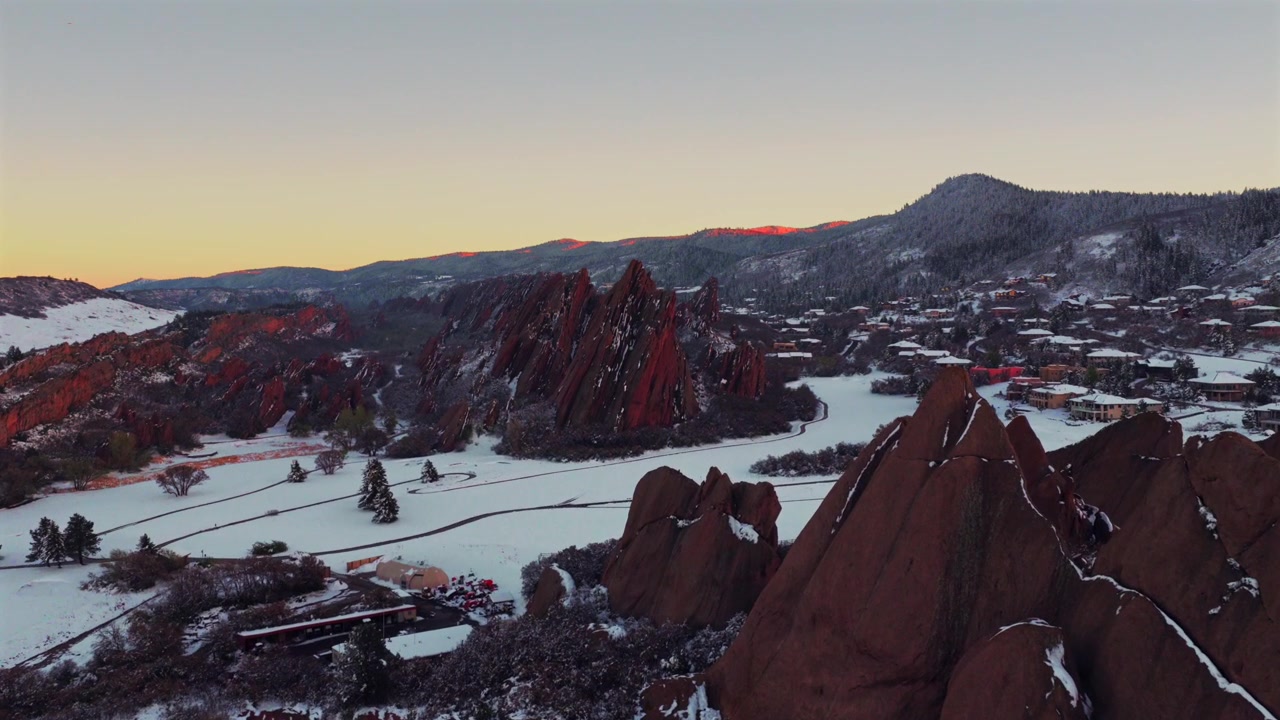Arrowheadin golfkenttä, Roxboroughin osavaltionpuisto, Fountain Valley -polku, lumipeitteiset Red Rocks -kalliot ja rosoinen hiekkakivi Littletonissa, Denverissä, Sterling Ranchissa, Coloradossa – ilmakuva dronella auringonlaskun aikaan Front Rangella eteenpäin liikkuen.