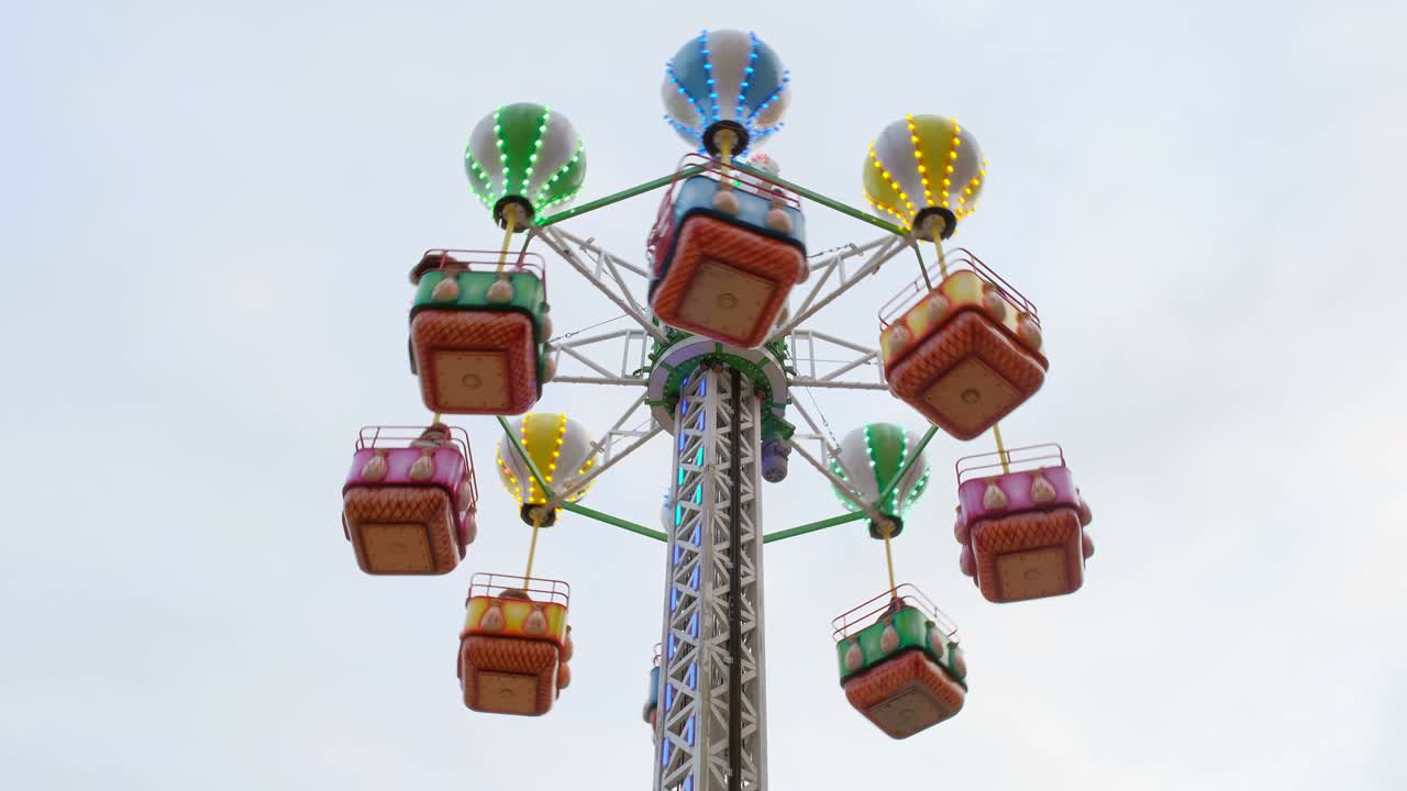 다채로운 카루셀이 하늘을 향해 회전합니다. 근접 사진. 놀이공원, 축제, 새해 박람회