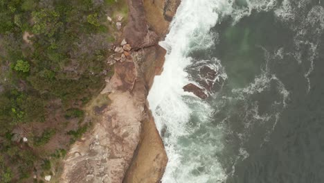 Waves-crashing-on-the-shoreline-sand-and-rocks