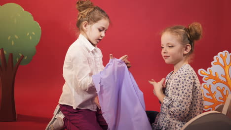 little girls scare each other. emotions of the child. studio shooting of children