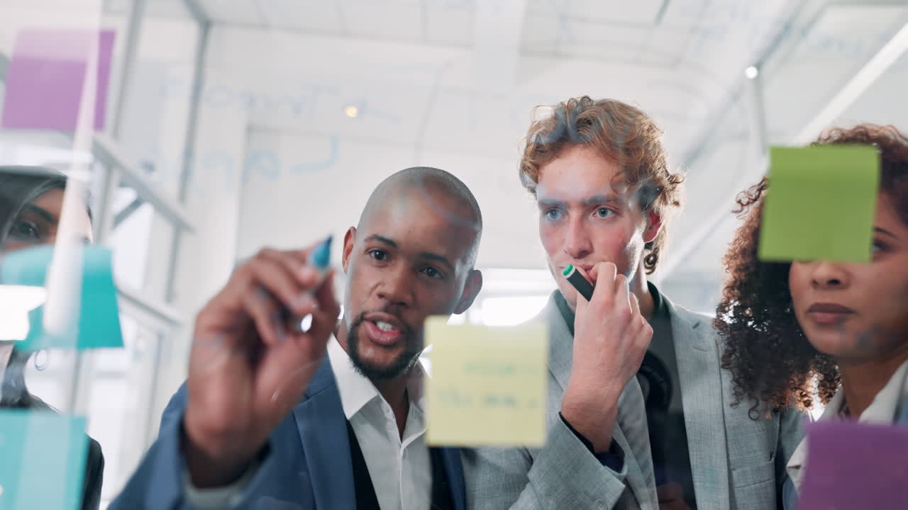 Diverse Business Team Collaborating on a Glass Whiteboard
