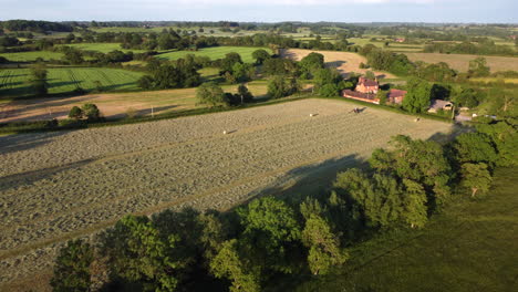 Long-evening-shadows-are-cast-over-the-land-as-a-tractor-works-in-a-field-in-the-Worcestershire
countryside-in-England