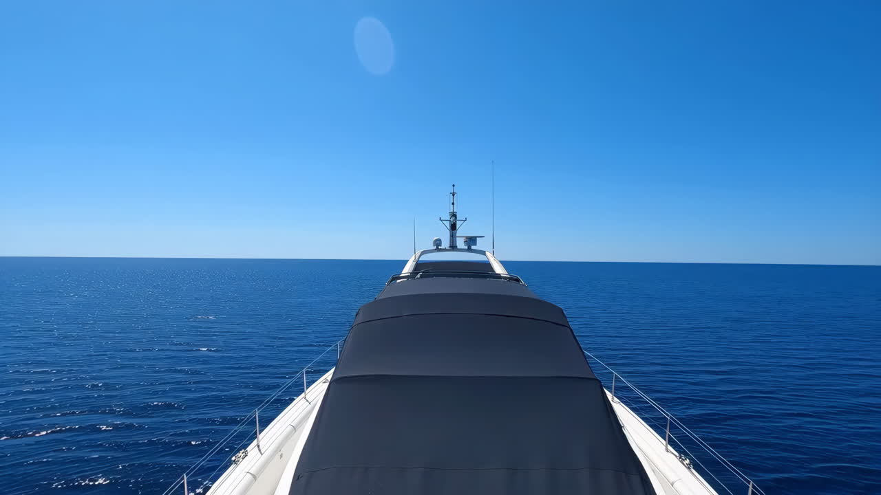 Front View of a Yacht on the Open Ocean Under a Clear Blue Sky