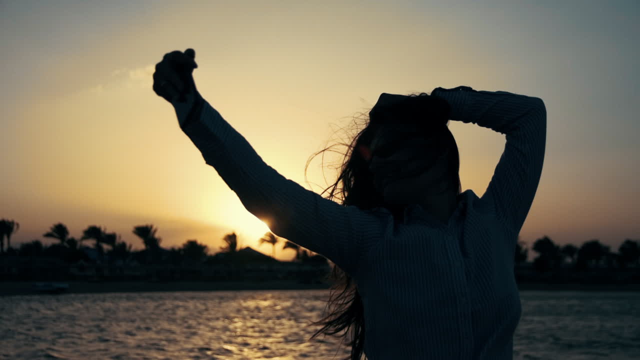 una mujer sonriente usando una cámara de teléfono en la playa. una chica hermosa posando en la playa.