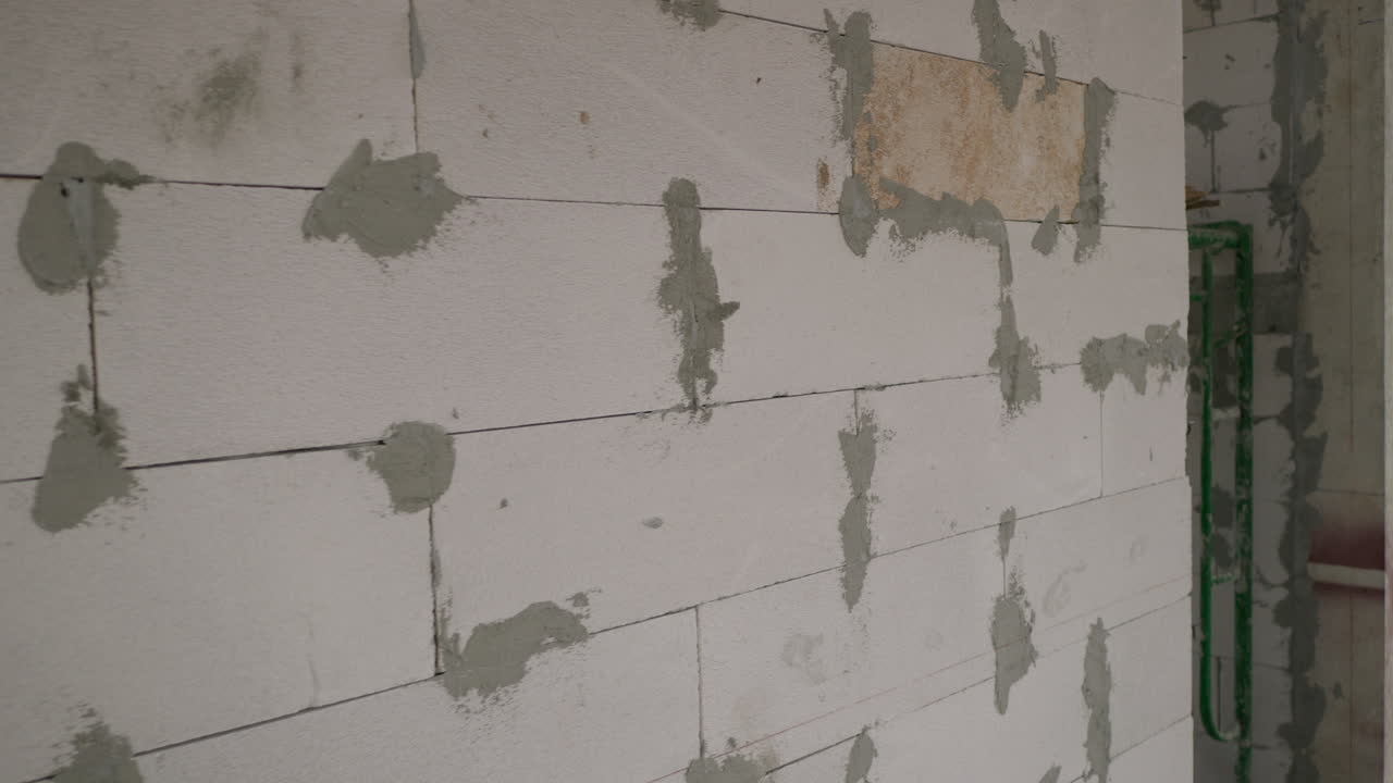 panorámica de la izquierda a la derecha del marco que muestra algunos bloques apilados uno encima del otro y revela una habitación en construcción dentro de un edificio