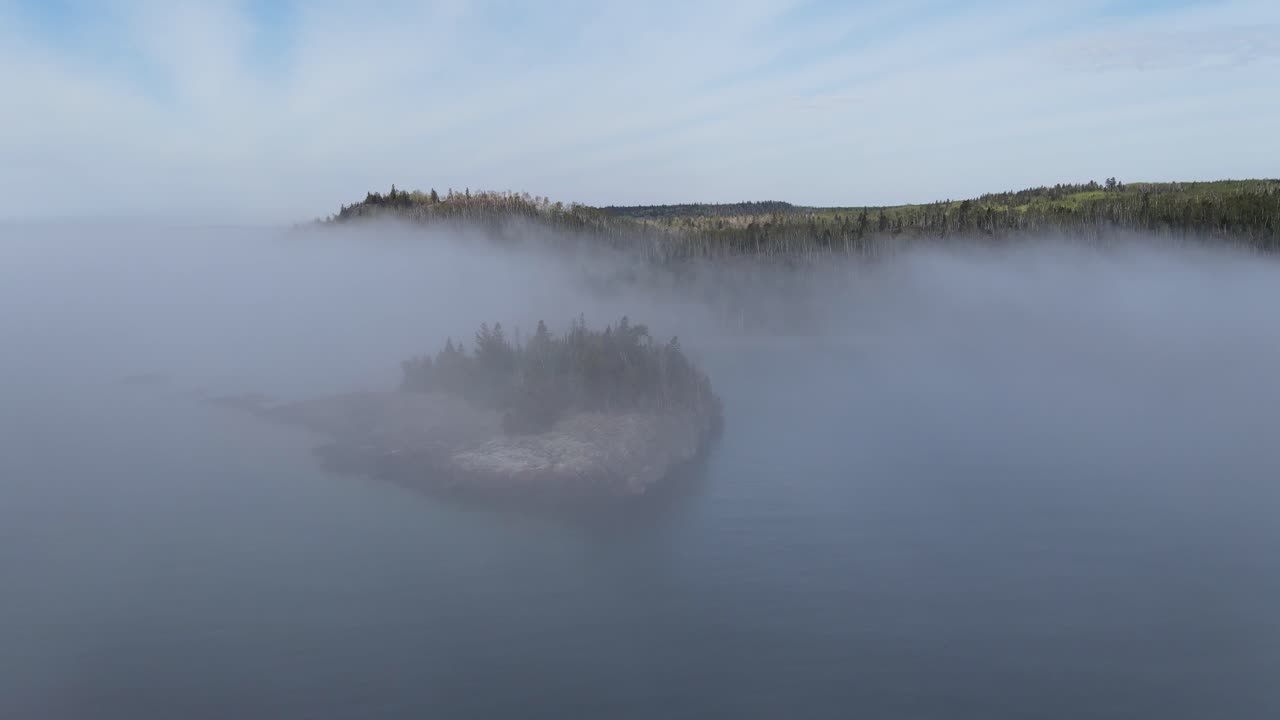 aerial footage of isle at lake superior during a foggy sunny summer morning at lake superior, minnesota