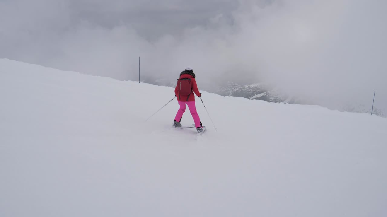Woman Skier Skiing Down The Mountain Slope In A Heavy Fog