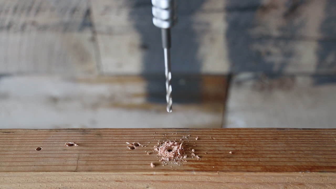 A drill bit drilling a hole into a piece of wood