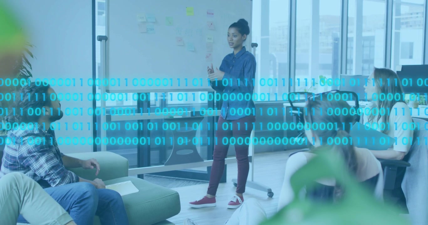 Woman leading project meeting, pointing board while cyan binary overlay fading in across notepad