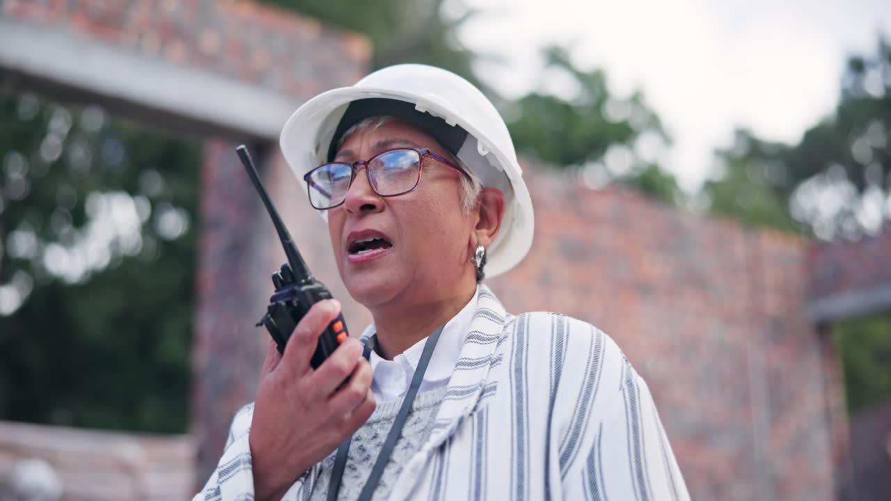 A construction worker with a walkie talkie on a construction site