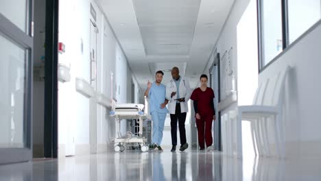 Diverse-doctors-discussing-work-and-walking-in-corridor,-slow-motion