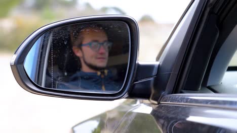 Toma-En-Cámara-Lenta-Del-Reflejo-De-Un-Conductor-En-El-Espejo-Retrovisor-Y-Se-Vuelve-Borrosa.