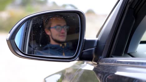 disparo en cámara lenta del reflejo de un conductor en el espejo del ala y se vuelve borroso