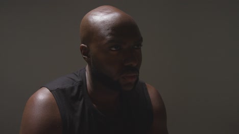 retrato de estudio de un atleta masculino con chaleco deportivo contra un fondo negro