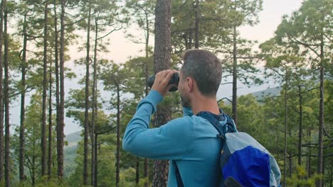 happy man admiring nature through binoculars