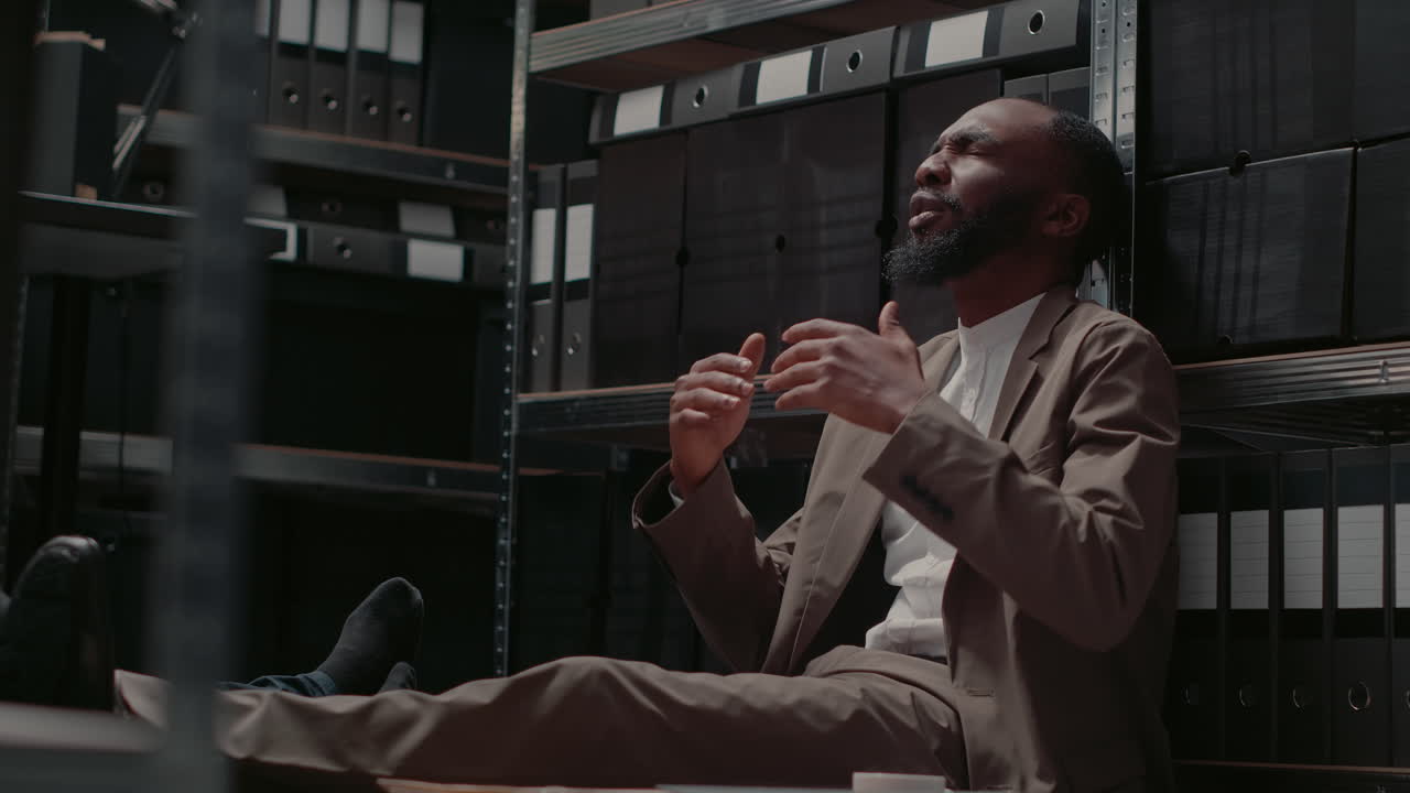 Tired Businessman Sitting in Warehouse