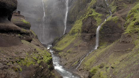 drone flying inside a canyon with waterfalls