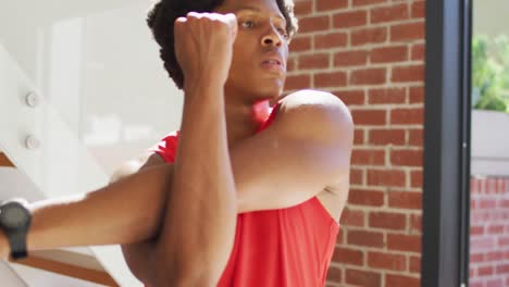 fit african american man exercising at home and doing stretching at home