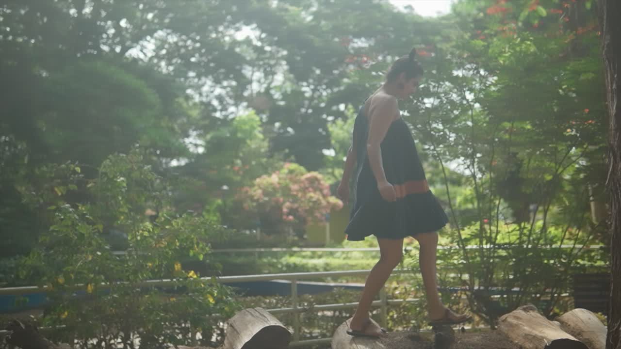 자연을 탐험하는 모험적인 여성 등반 통나무는 환경에서  ⁇ 빛과 함께 우아하고, 균형 있고, 조화를 이루며 잘라집니다.