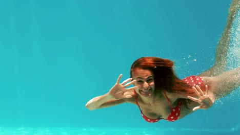 mujer sonriente nadando bajo el agua