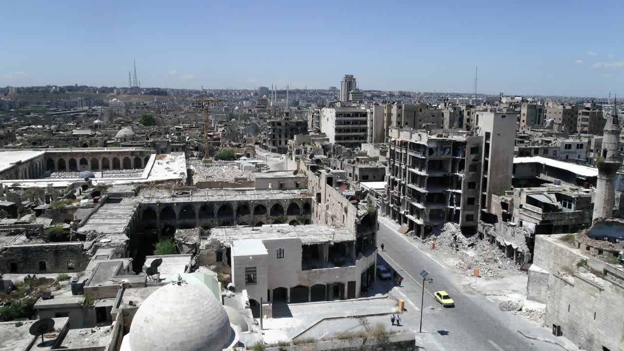 도로를 달리는 자동차가 있는 시리아 도시: 10 년 전 내전 이후 일부 건물은 여전히 폐허입니다.