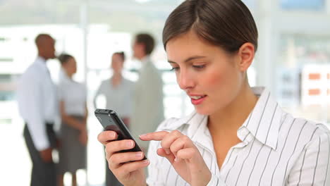 una trabajadora enviando mensajes de texto en su teléfono móvil