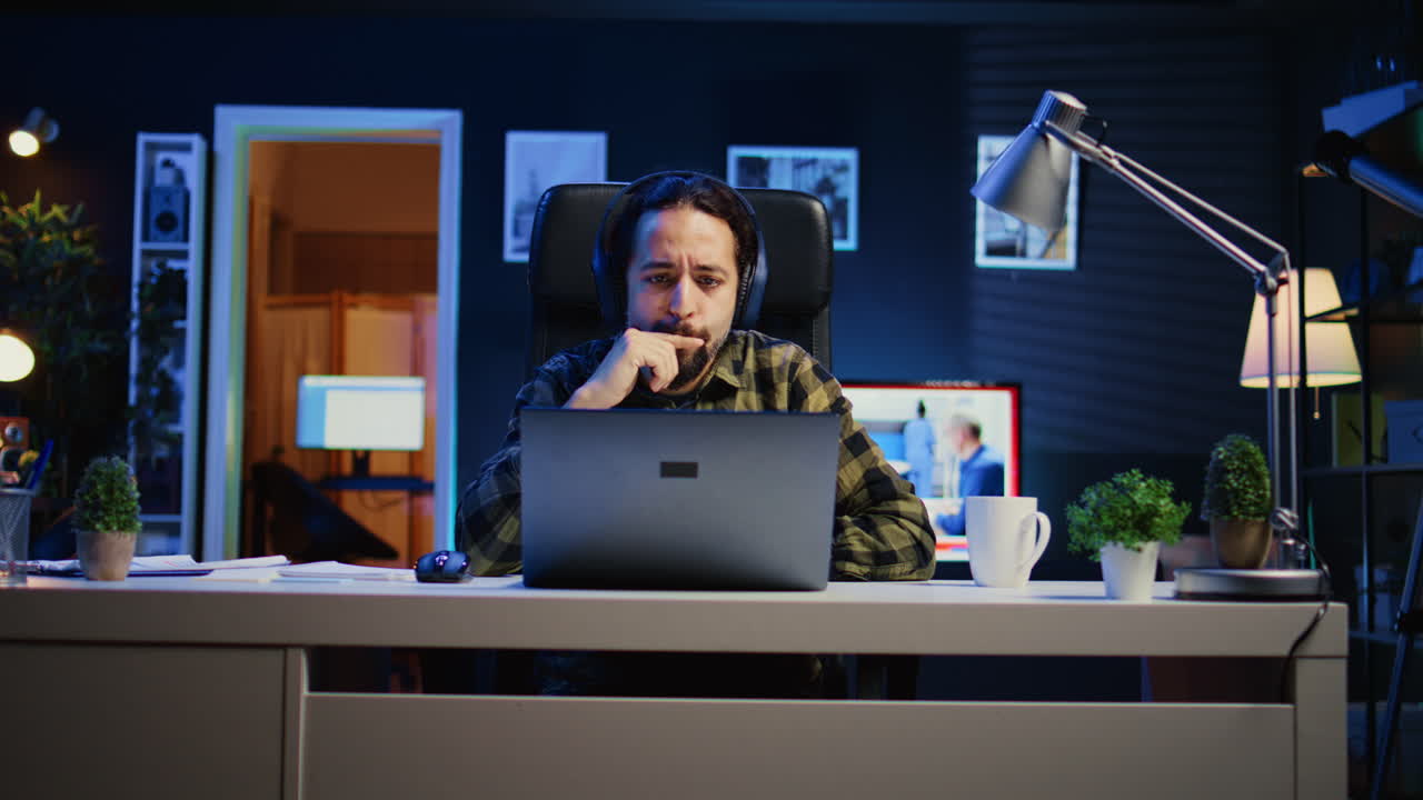 집 사무실 책상 에서 의자 에 앉아서 음악 을 듣고 일 하는 사람