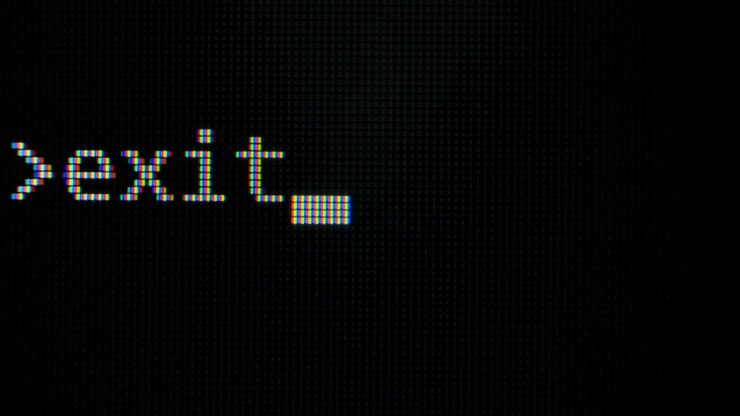 Command line with word Exit typed on computer screen closeup . Macro detail shot monitor pixels. Pixels zoomed in with white glowing crystals on a black background