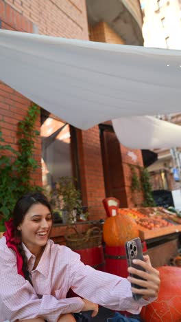 young woman taking selfie at an outdoor market