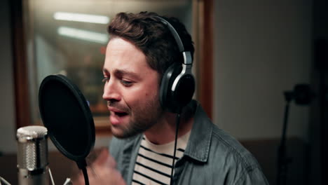 man singing into a microphone in a recording studio