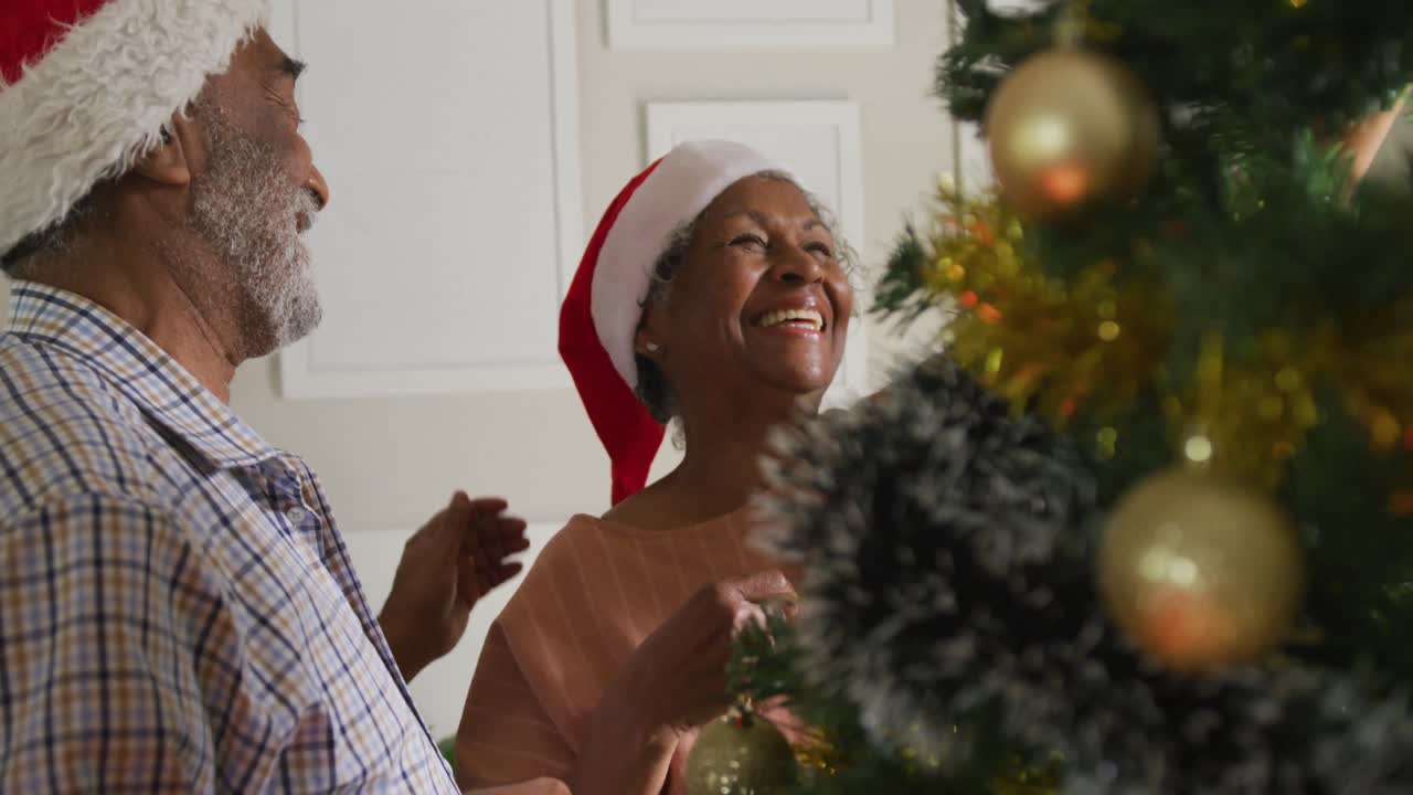 animación de una feliz pareja de adultos mayores afroamericanos que decoran juntos el árbol de navidad