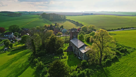 Drone-footage-displays-Burwell-village,-once-a-medieval-market-town,-encompassing-country-fields,-historic-red-brick-homes,-and-the-obsolete-Saint-Michael-parish-church-atop-the-Wold-Hills